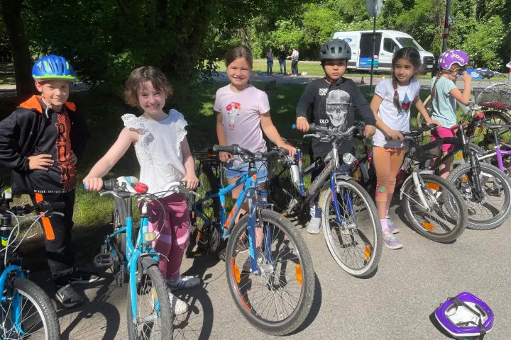 Sechs Kinder stehen neben ihren Fahrrädern